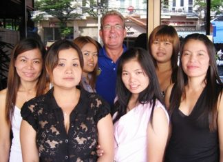 ‘Broken Wing’, center-rear, celebrates his golfing success with the staff at Kisses Bar in Ban Chang.